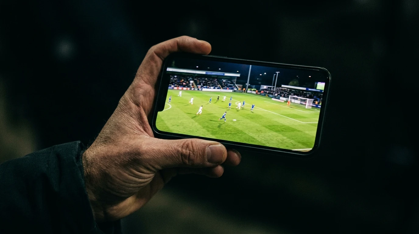 Smartphone a transmitir um jogo de futebol em direto com campo verde no ecrã